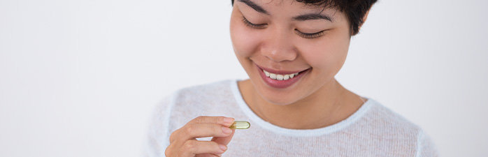 Smiling woman taking oral decongestant